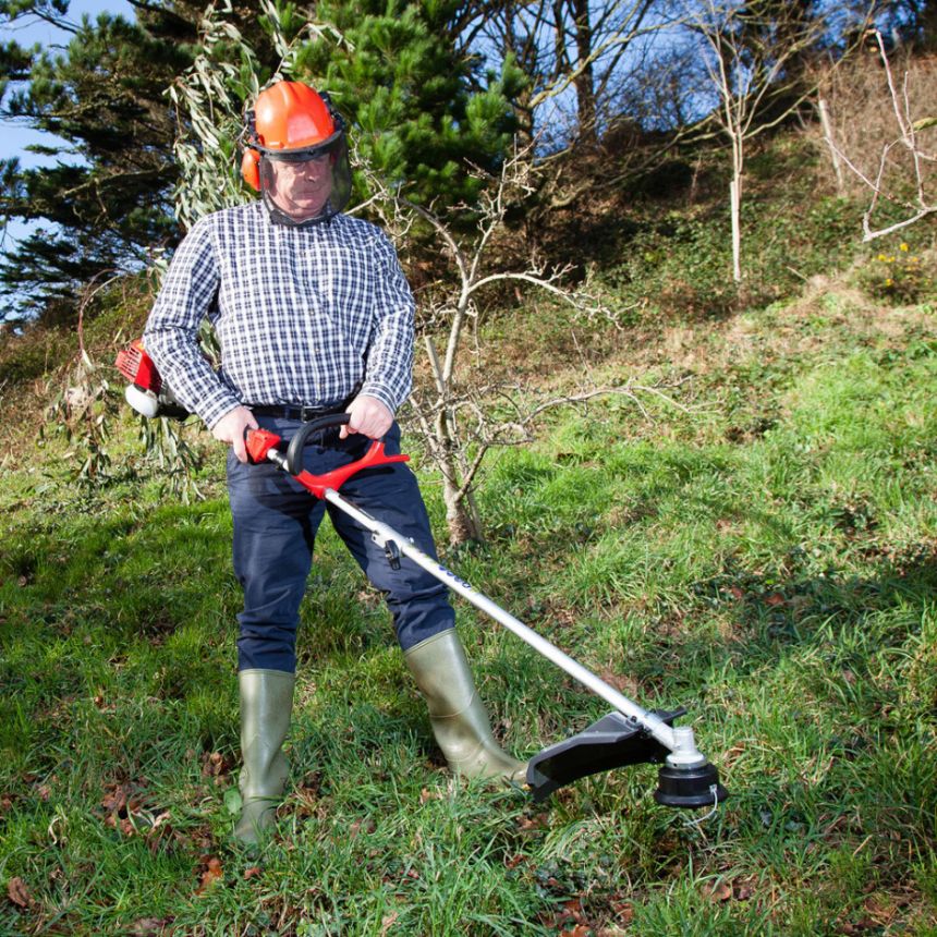 m_f_MM2603_multi_tool_7 - Mowers Online Man using string trimmer on hillside grass