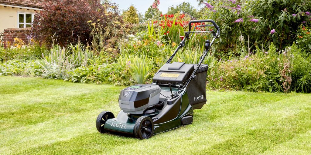 Black electric lawn mower on grass