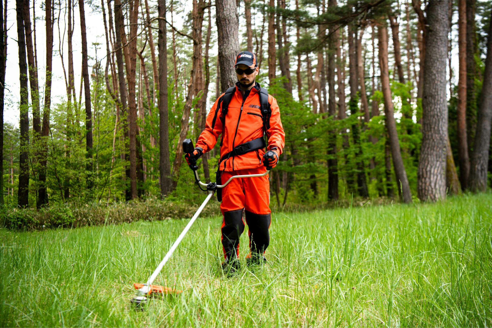 4wa0r2gbwtq.jpg - Mowers Online Person using string trimmer in forest clearing