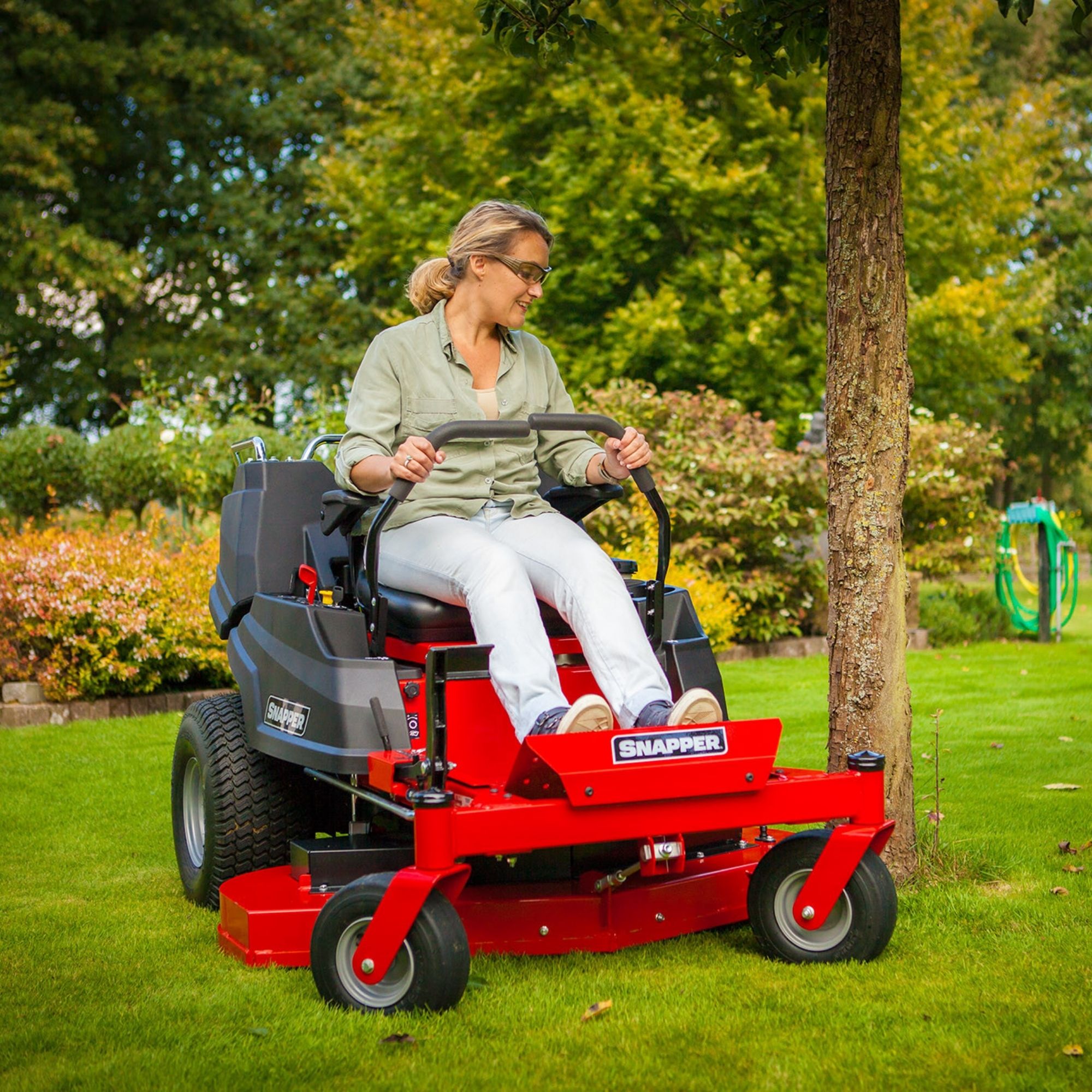 gcwhpktlce2.jpg - Mowers Online Man operating red zero-turn radius lawn mower