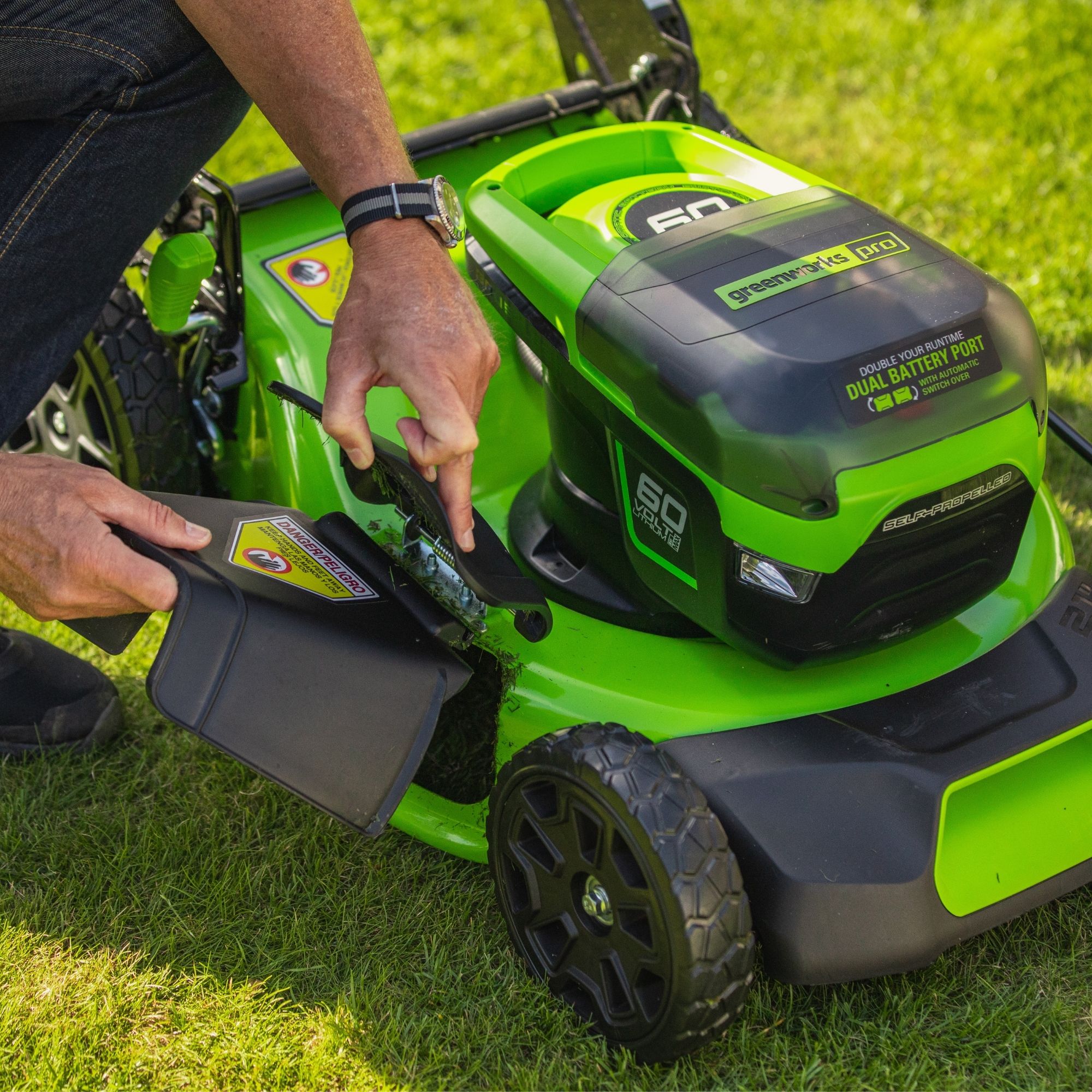 gjc1ucgm4n3.jpg - Mowers Online Person operating green robotic lawn mower