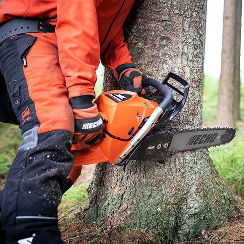 gxmbatpuc3s.jpg - Mowers Online Person operating chainsaw against tree trunk