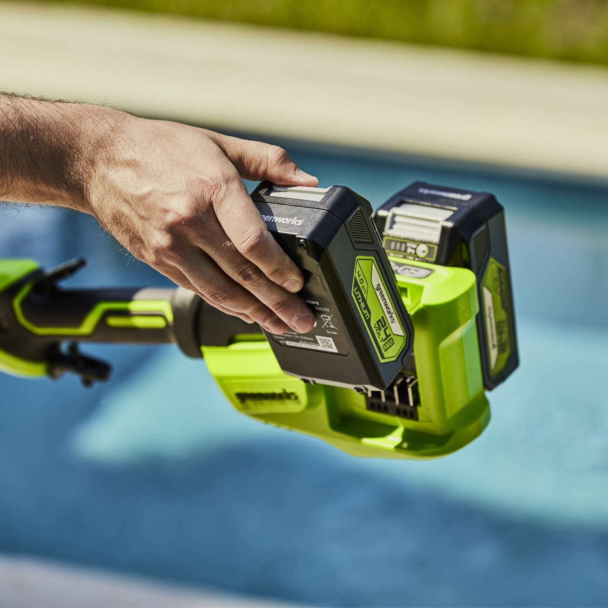 iwxgbg0kynx.jpg - Mowers Online Person holding cordless power tool battery pack