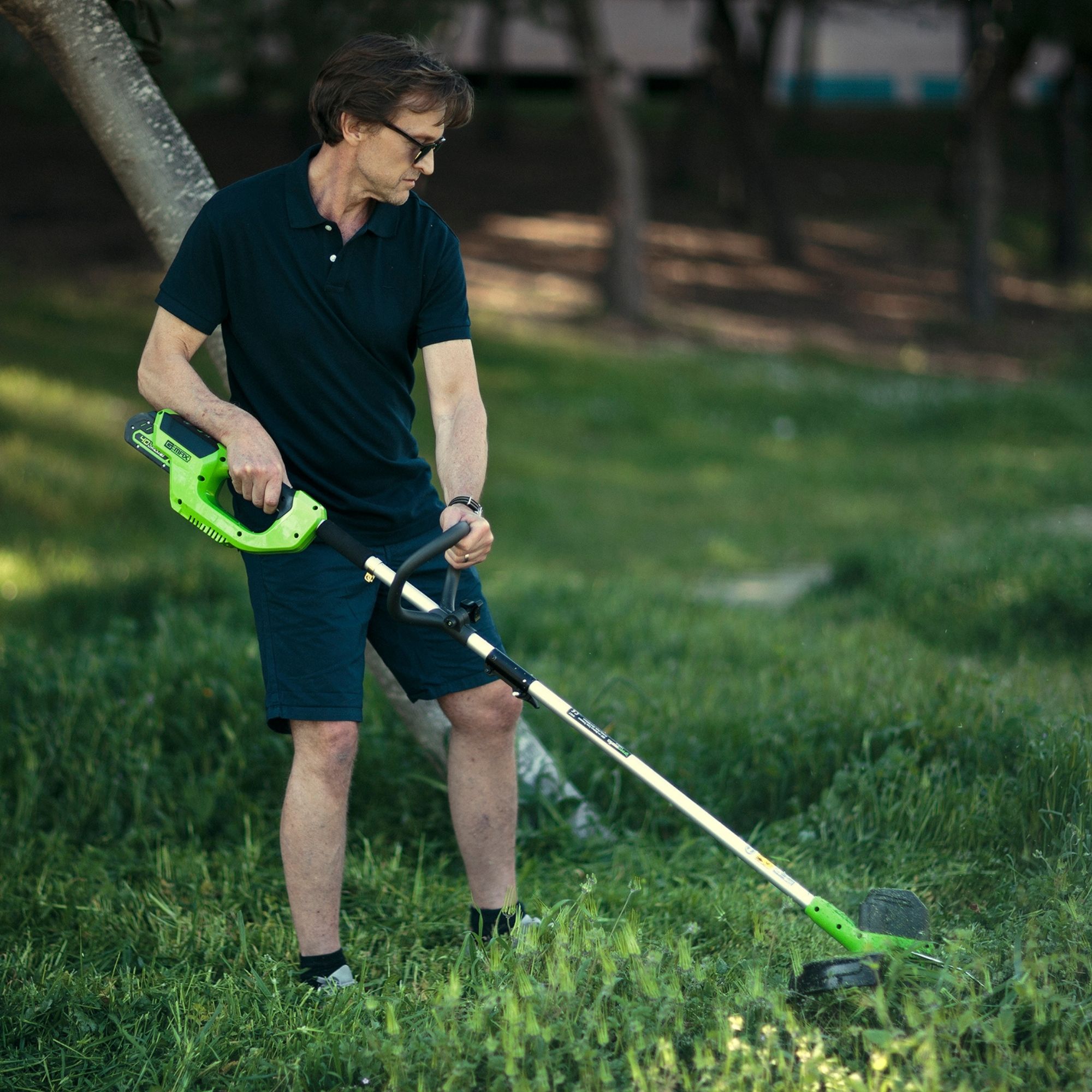 j44kjy5vt2x.jpg - Mowers Online Man using cordless string trimmer on grass