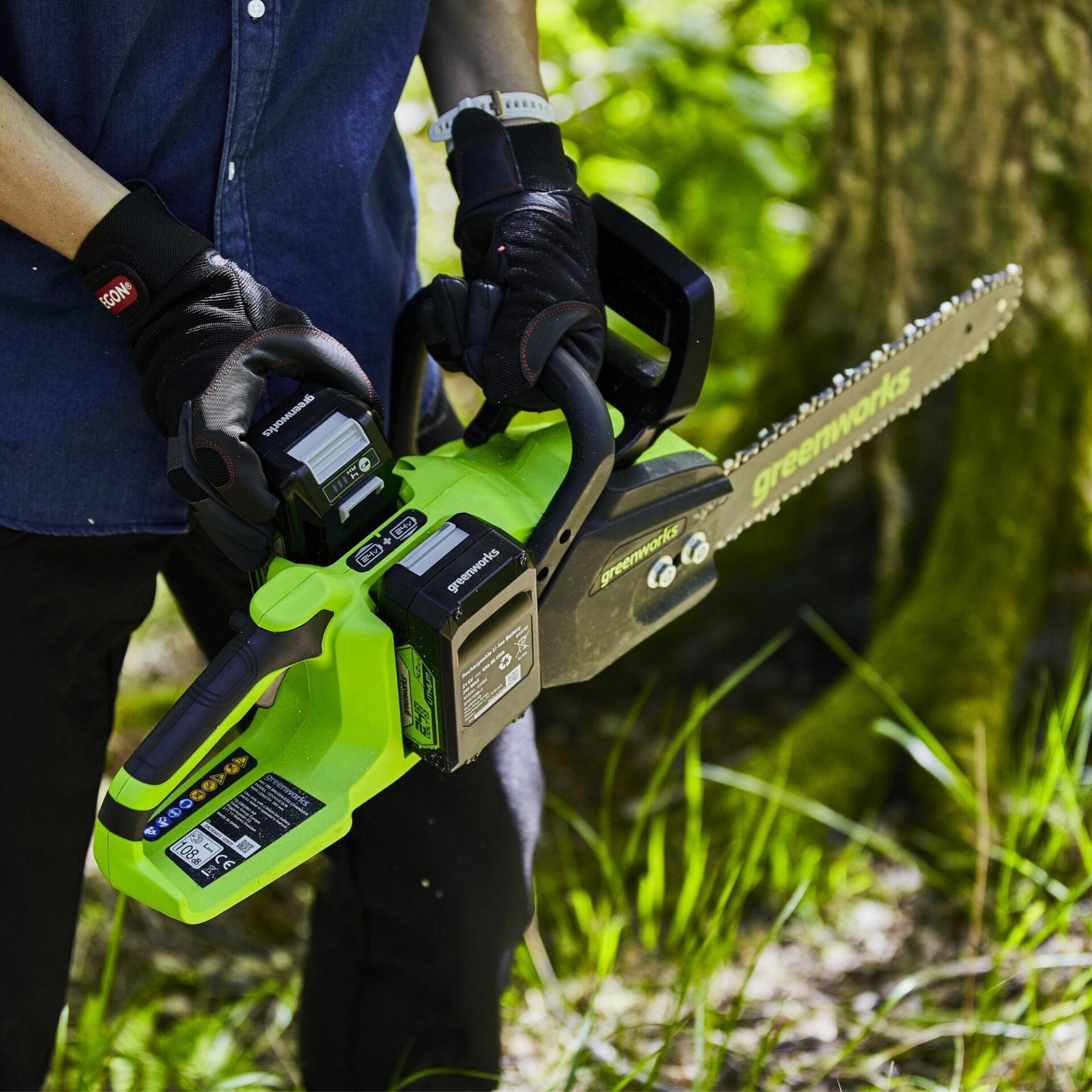 jccg0f5dwvf.jpg - Mowers Online Person holding electric chainsaw in outdoor setting