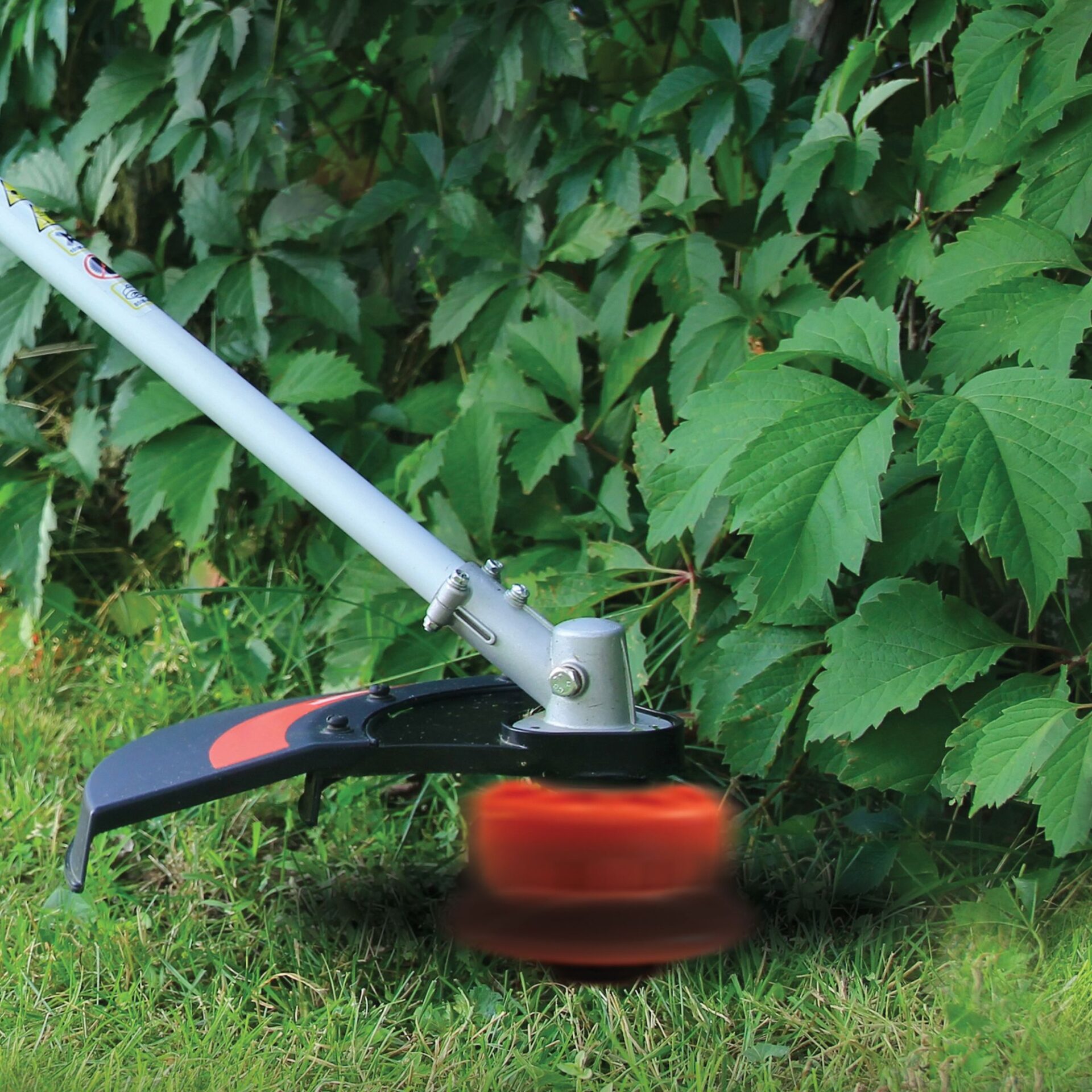 jx25uvjmfld.jpg - Mowers Online String trimmer with orange fuel tank and white shaft