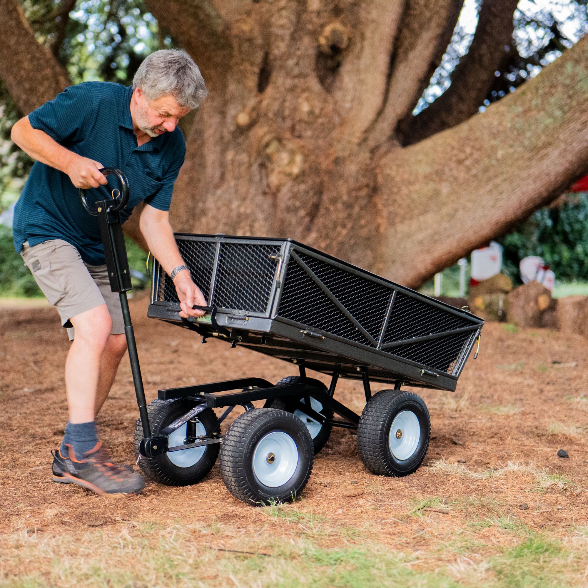 lnrsy31eeuo.jpg - Mowers Online Man using yard cart with mesh bed