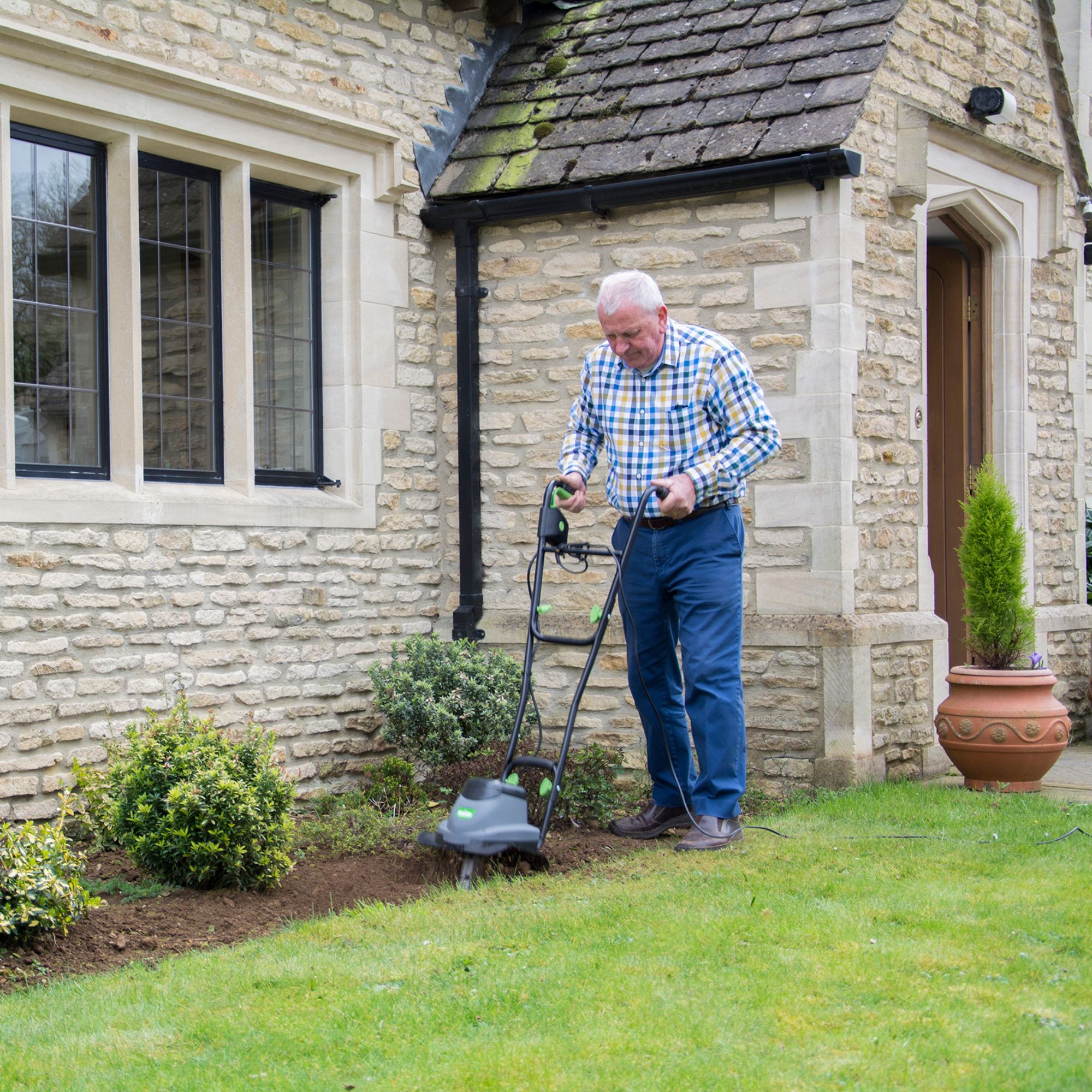 n5o0nt5vwee.jpg - Mowers Online Man operating electric lawn mower on grass