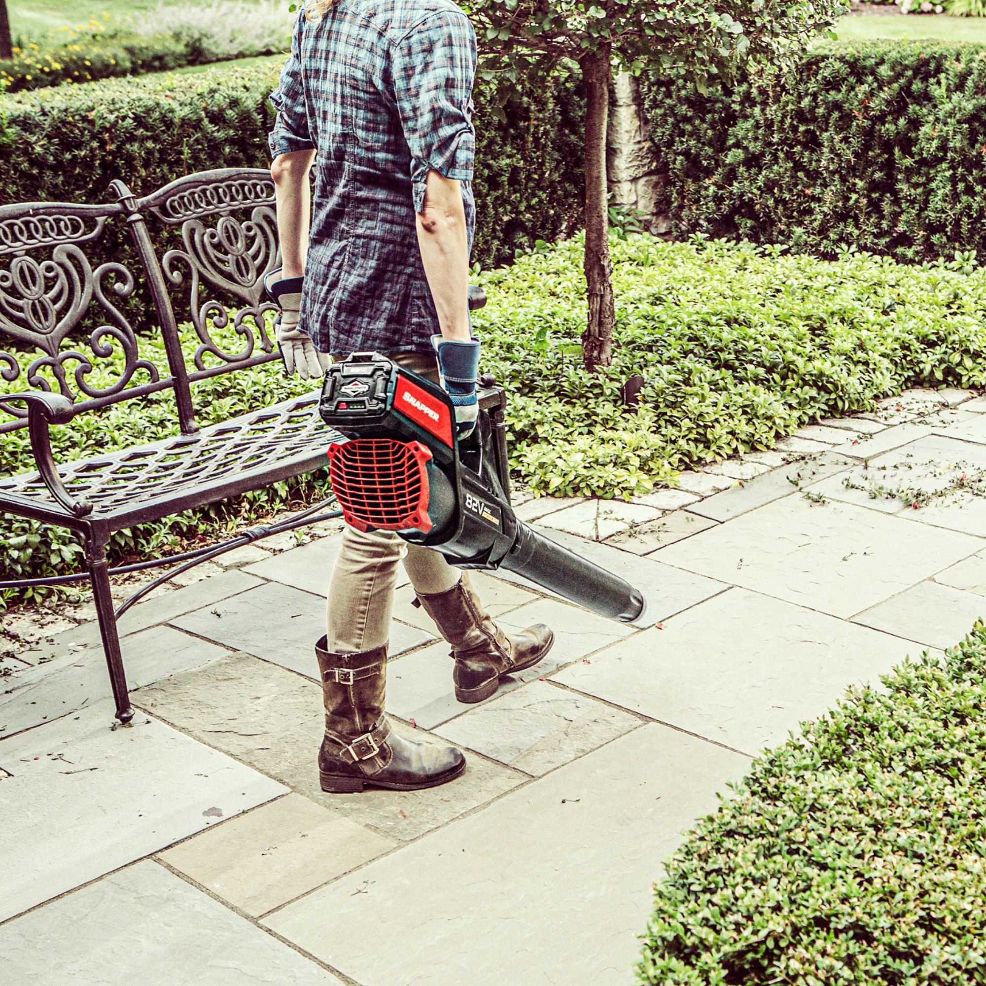 sl0pj5cmryj.jpg - Mowers Online Person holding leaf blower in garden