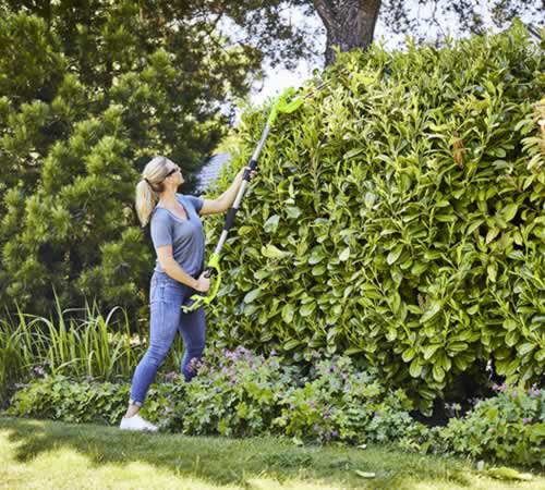 stz4kk1bqic.jpg - Mowers Online Woman using pole pruner on hedge