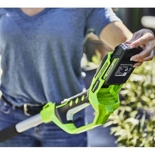 C - Mowers Online Person holding green cordless hedge trimmer