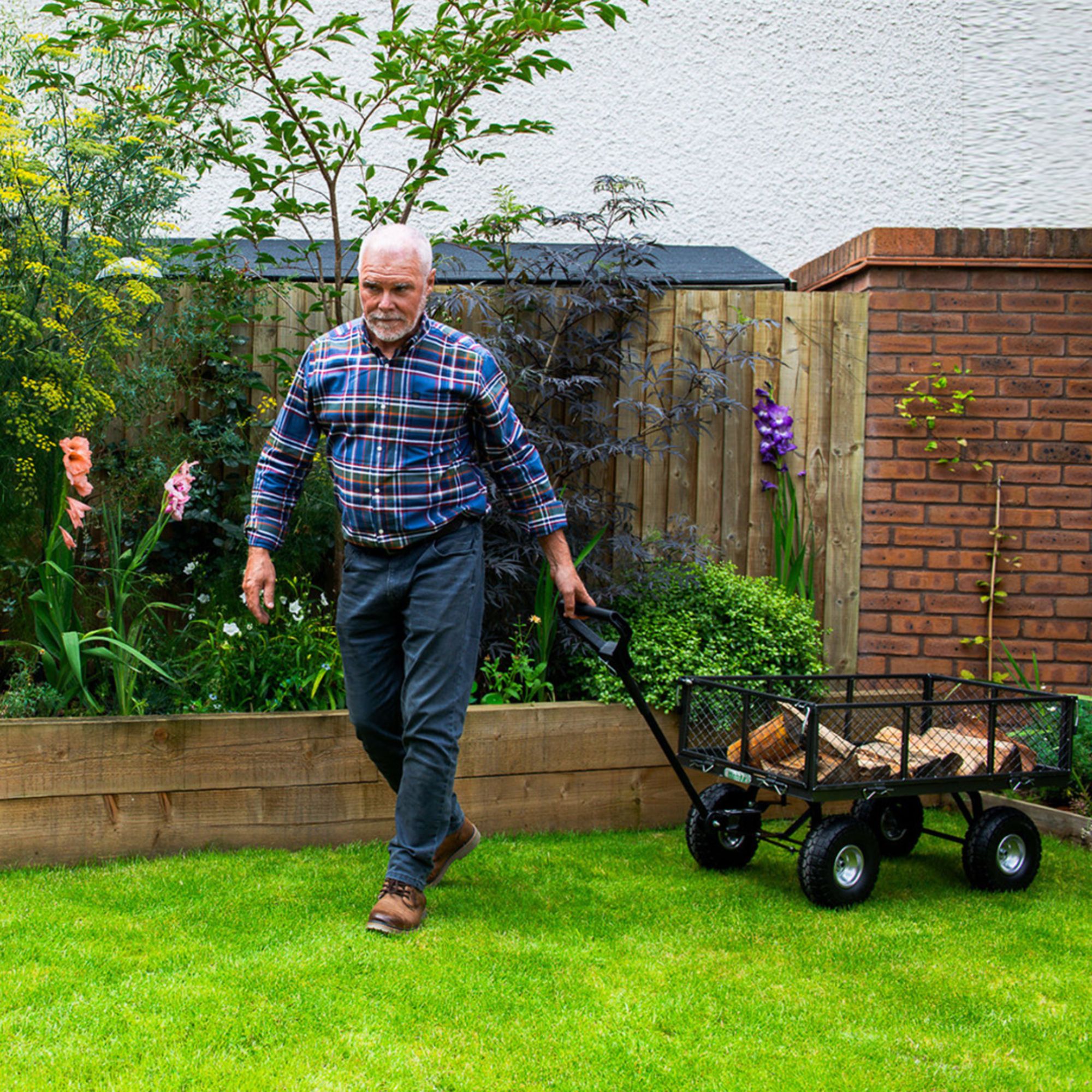 z5n0k0orcwx.jpg - Mowers Online Man pulling garden cart on lawn