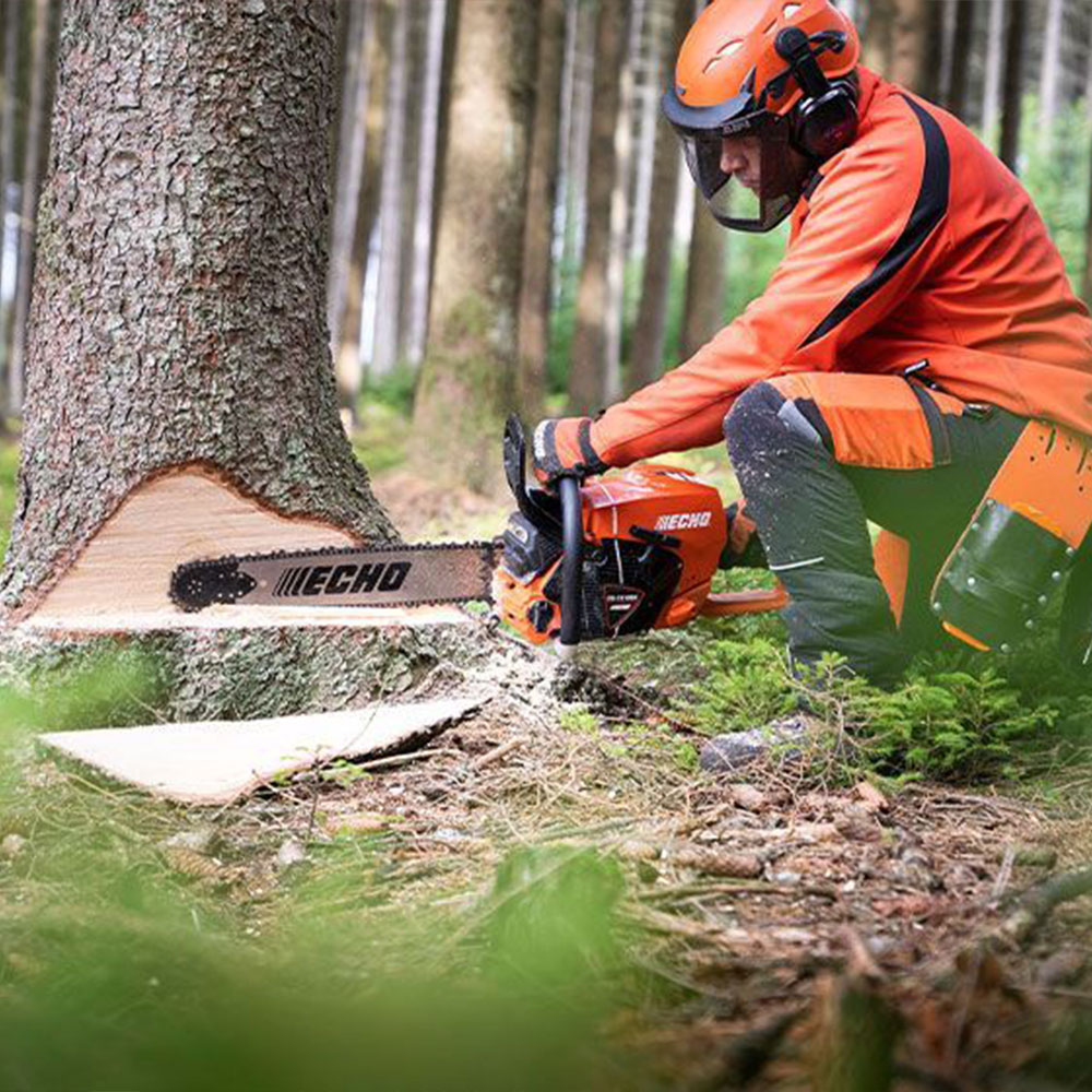 zhchsxmt50z.jpg - Mowers Online Person using chainsaw to fell tree